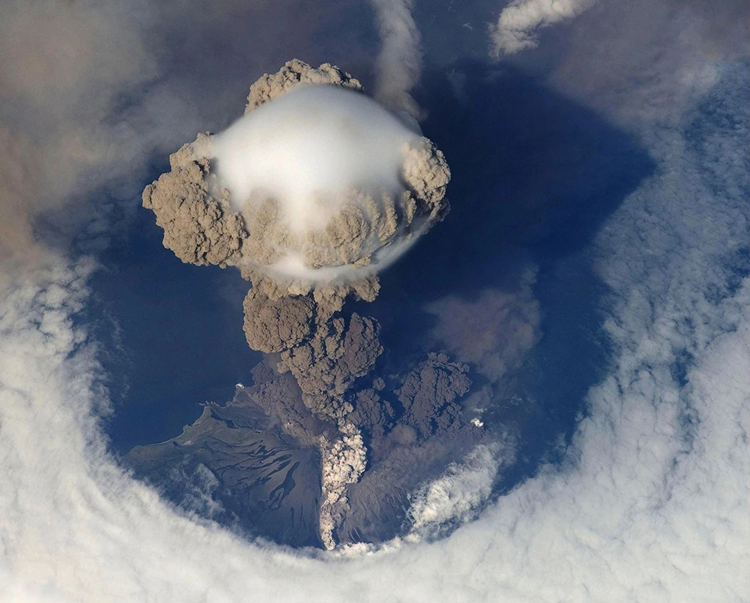 A large crater with smoke coming from it.